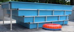 an inflatable raft sitting on the ground next to a large blue container with dividers