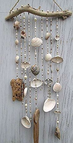 a wall hanging with shells and seashells attached to it's sides on a wooden surface