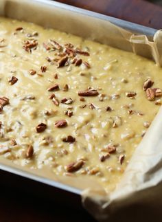 a pan filled with batter and pecans on top of a table