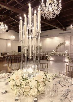 an elegant centerpiece with candles and flowers on a table at a wedding reception in the ballroom