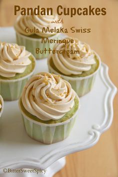 cupcakes with white frosting sitting on a cake platter that says pandan cupcakes and coca - melka swiss buttercream