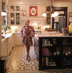 a woman standing in the middle of a kitchen