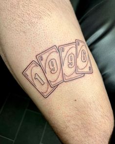 a man's leg with four playing cards tattoo on it