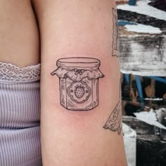 a woman with a tattoo on her arm has a jar of jam tattooed on it