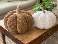 two stuffed pumpkins sitting on top of a wooden table in front of a couch