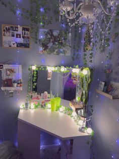 a desk with a mirror, lights and plants on it in a room that is lit up