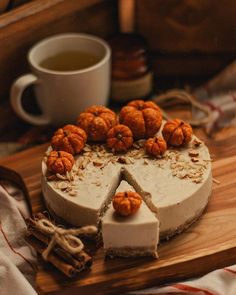 there is a cake with nuts on it and a cup of tea in the background