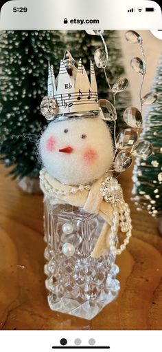 a small snowman with a crown on it's head