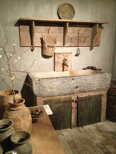 an old wooden table with vases and other items on display in a museum setting