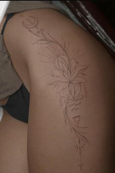 the back of a woman's thigh with a tattoo on her left side and an arrow in the middle