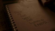 an open notebook with the words this is the way the world ends written on it