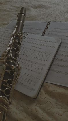 an instrument sitting on top of sheets of music paper next to a notepad and pen