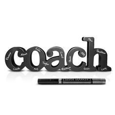 the word coach written in black letters next to a marker and pen on a white background