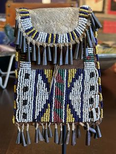 the beaded purse is hanging on a stand