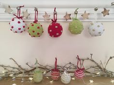 crocheted ornaments are hanging on the wall next to branches and star garlands