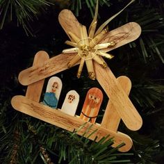 a wooden ornament hanging from a christmas tree with nativity pictures on it