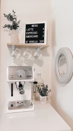 a coffee machine sitting on top of a white counter next to a sign that says cafe latte