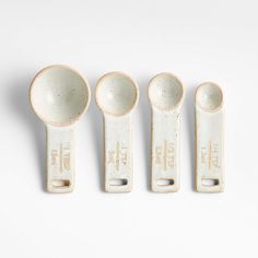 four ceramic measuring spoons lined up next to each other