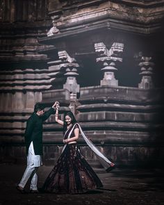 a man and woman dancing in front of an old building