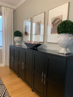 a living room with black cabinets and white vases