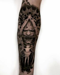 a man's leg with a black and grey tattoo design on it, featuring an image of a woman