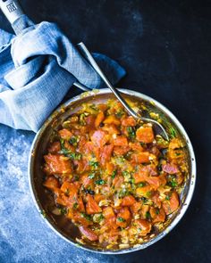 a large pot filled with food on top of a blue table cloth next to a spoon