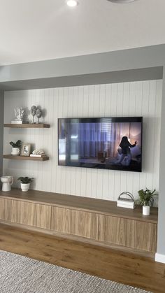 a flat screen tv mounted to the side of a wooden shelf in a living room