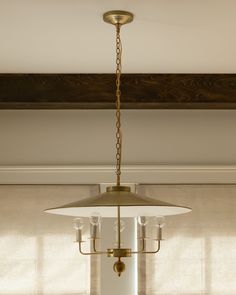 a light fixture hanging from the ceiling in a room with blinds on the windowsill