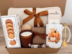 a gift box filled with cookies, crackers, coffee mugs and other items