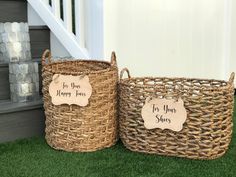 two baskets with signs on them sitting in the grass