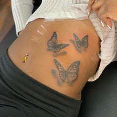 a woman's stomach with butterflies on it and the bottom part of her belly