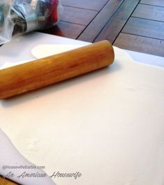 a rolling pin sitting on top of a piece of paper next to a roll of dough