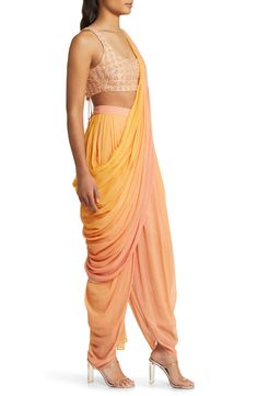 Achieve elegance in an eye-catching set that includes a hand-embroidered midriff-baring top and dance-all-night dhoti pants. The booti-work dupatta is attached to the outfit, so you don't have to worry about pleats or the right draping—just wrap it around and over your shoulder. 13" top length; 27" inseam; 14" leg opening; 17" front rise; 19" back rise Ties at back Top has scoop neck; sleeveless Side-seam pockets Pants and drape feature hook-and-eye attachments for easy adjustments Lined 100% vi Indowestern Outfits, Indian Pants, Midriff Dress, Bridal Bustier, Haldi Outfits, Salwar Pants, Desi Outfits, Dhoti Pants, Pockets Pants