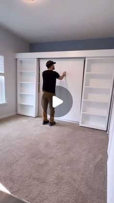 a man standing in front of a white closet with shelves on both sides and doors open