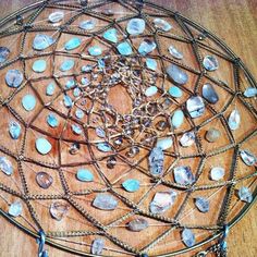 a wooden table topped with lots of different types of necklaces and pendants on it