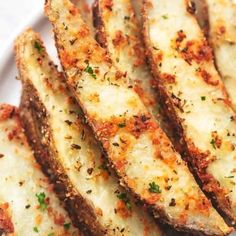 some fried food on a white plate with parmesan and seasoning sprinkles