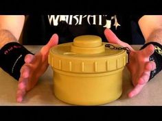 a person with their hands on a yellow container