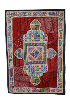 an embroidered wall hanging with colorful designs on it