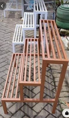 four chairs sitting next to each other on top of a brick floor in front of a building