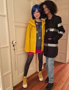 two people standing next to each other in front of a door wearing yellow jackets and striped tights