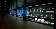 a room filled with lots of glass shelves covered in trophy cups and vases on display