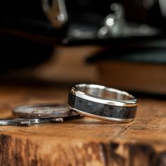 two wedding bands sitting on top of a wooden table