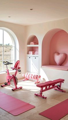 a pink room with exercise equipment and yoga mats