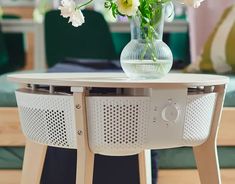 a vase with white flowers sitting on top of a wooden table next to a couch