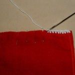 a red piece of fabric with a needle hooked up to it