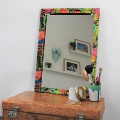 an old suitcase with a mirror and makeup brushes on it