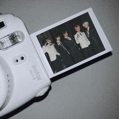 a polaroid camera sitting on top of a table next to an image of the same person