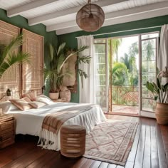 a bedroom with green walls and wooden floors, large bed surrounded by potted plants