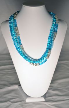 Handmade Beaded Multi Strand Necklace with Turquoise Blue Crystals, Clear Glass Beads and Tonal Turquoise Blue Beads with a Watermark.  Necklace has Silver Accents and a Silver Lobster Claw Clasp.  Necklace Measures 22 Inches Long. Blue Multi-strand Spacer Beads, Multi-strand Blue Spacer Beads, Turquoise Multi-strand Beads For Jewelry Making, Turquoise Beaded Czech Glass Necklace, Bohemian Blue Beaded Crystal Necklace, Blue Czech Glass Beads For Beach, Turquoise Beaded Necklaces For Beach With Faceted Beads, Blue Multi-strand Turquoise Necklace With Colorful Beads, Multi-strand Turquoise Necklace With Polished Beads