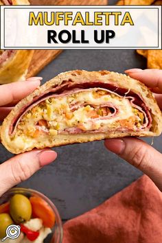 a person holding a half eaten sandwich in their hand with the words muffaletta roll up above it